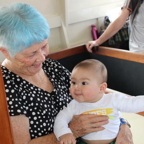 Woman smiles down at a happy baby while enjoying a glass bottom boat tour