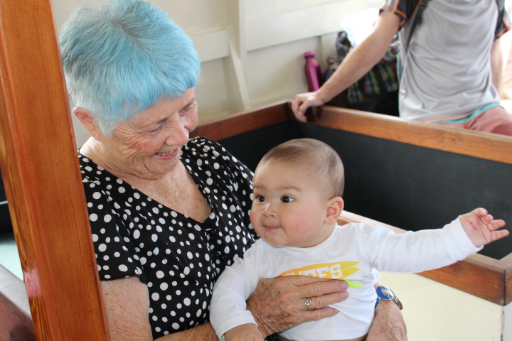 Woman smiles down at a happy baby while enjoying a glass bottom boat tour