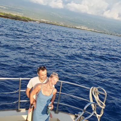 a person standing in front of a boat next to a body of water