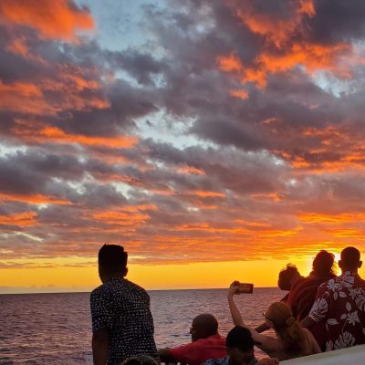 a group of people standing in front of a sunset